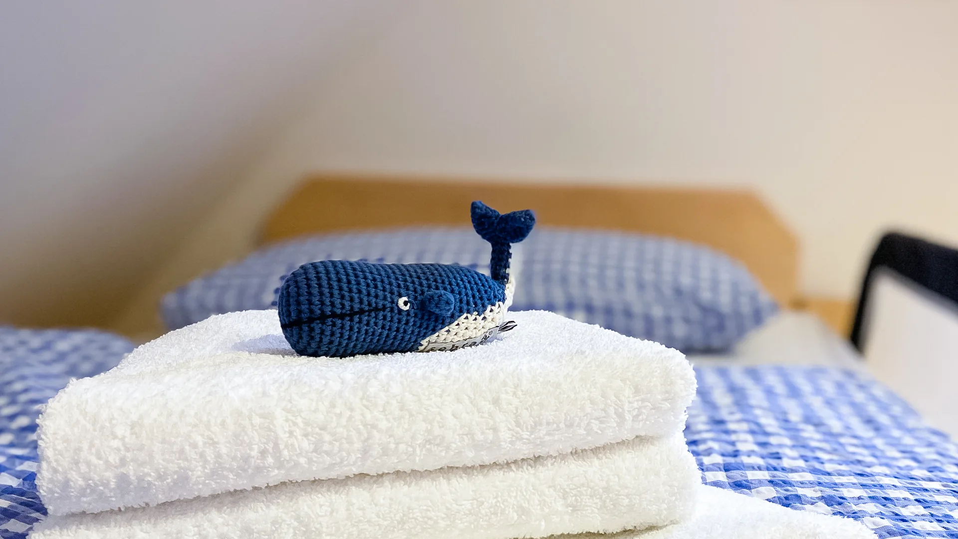 Hauptschlafzimmer des Ferienhauses im zweiten Stock mit Bett, Bettdecke und Kuscheltier